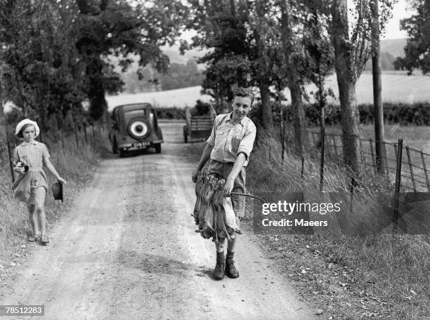 Year-old evacuee Teddy Neale with a catch of rabbits near Stanton in the Cotswolds, 10th August 1944. Teddy, his mother and sister are from Shepherds...