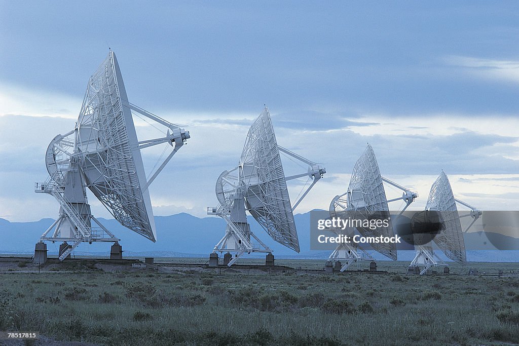 Satellite dishes in rural field