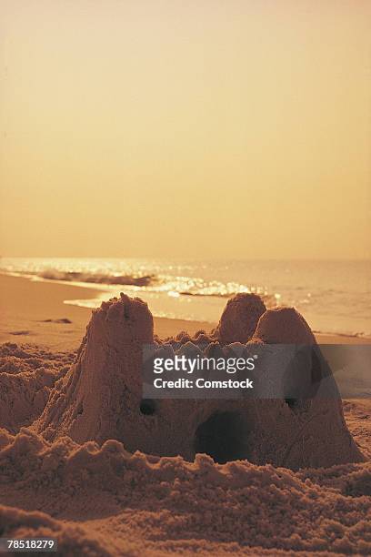 sand castle on beach at sunset - sand sculpture stockfoto's en -beelden