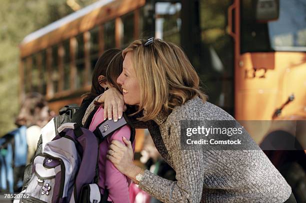 mother hugging daughter - school bus kids stock pictures, royalty-free photos & images