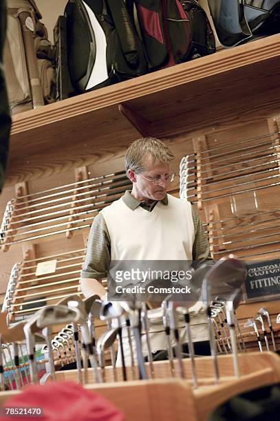 man in sports equipment store - golf merchandise stock pictures, royalty-free photos & images