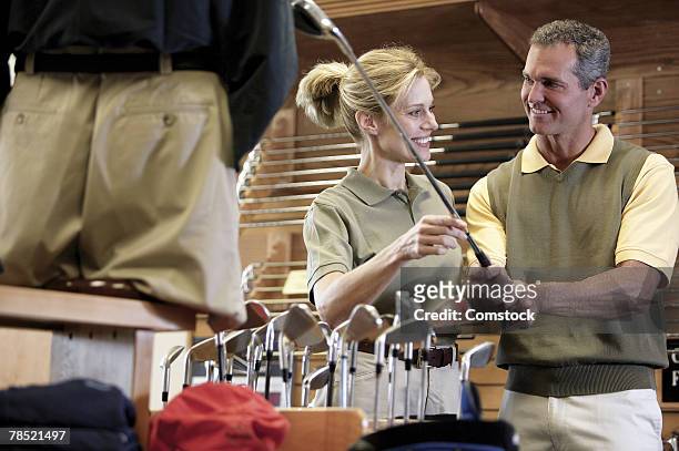 couple shopping for golf clubs - golf merchandise stock pictures, royalty-free photos & images