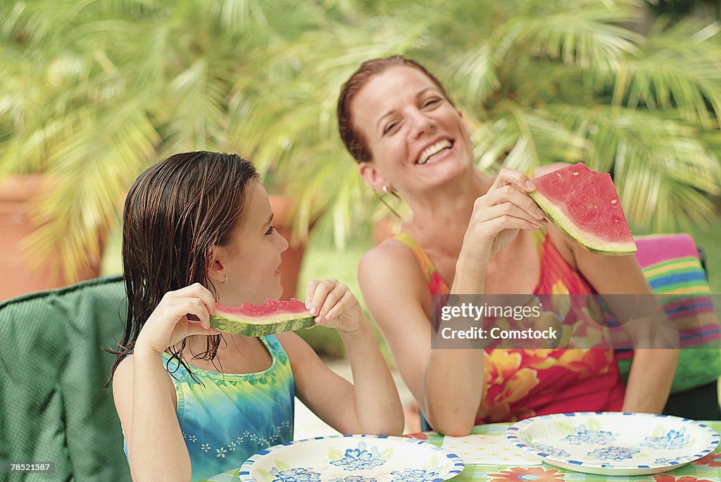 Mother and daughter eating watermelon