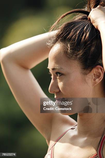 woman pulling hair back - woman pulling hair back stock pictures, royalty-free photos & images