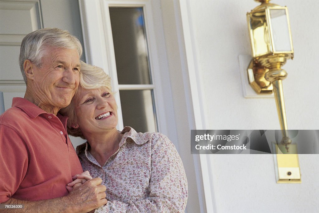 Happy couple in doorway of home