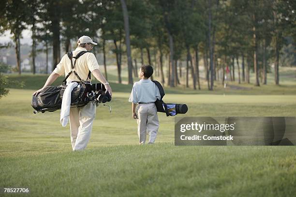 father and son on golf course - father son golf stock pictures, royalty-free photos & images