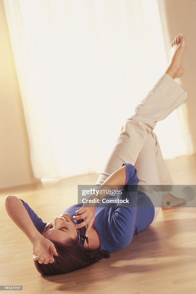 Woman lying on floor with cell phone