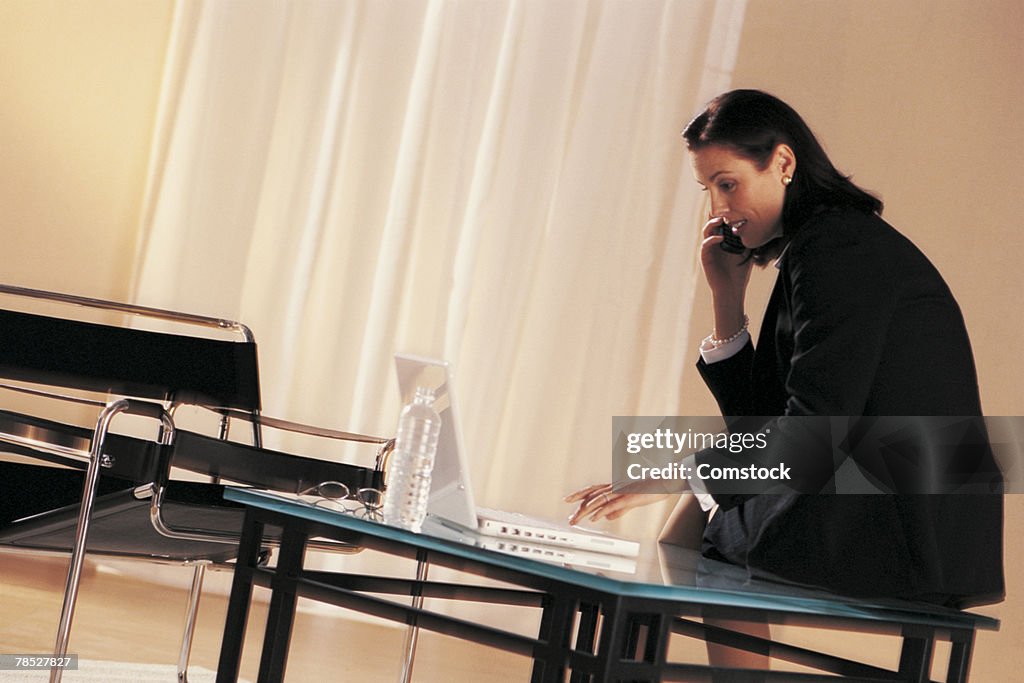 Businesswoman with laptop and cell phone