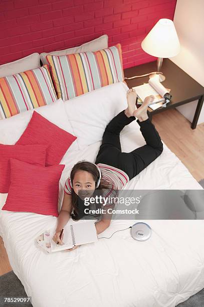teenager writing and listening to music on portable device - rom above stock pictures, royalty-free photos & images