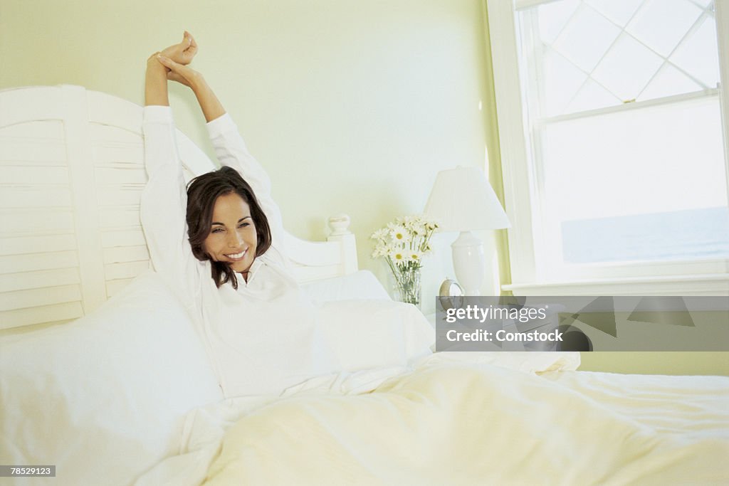 Woman stretching in bed