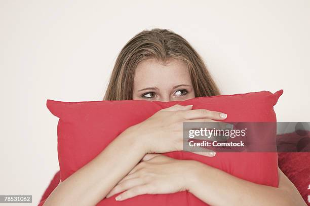 teenager hiding behind pillow - kuscheldecke stock-fotos und bilder