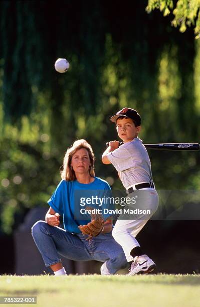 baseball, boy (7-9) about to hit  ball, mother acting as 'catcher' - baseball mom stock pictures, royalty-free photos & images