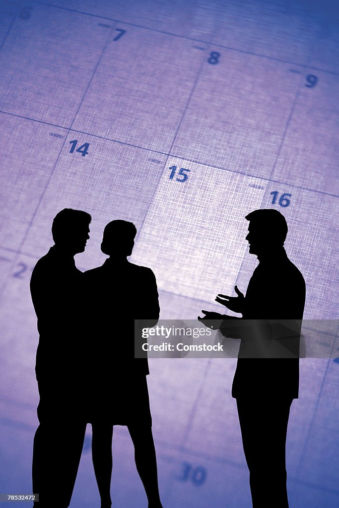 Composite of silhouette of businesspeople and calendar