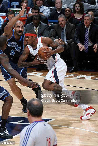 Josh Smith of the Atlanta Hawks drives to the basket against Carlos Boozer of the Utah Jazz at Philips Arena on December 17, 2007 in Atlanta,...