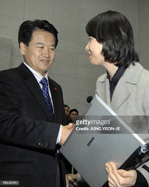 Chung Dong-Young , South Korean presidential candidate for the pro-government United New Democratic Party, shakes hands with a reporter at the end of...