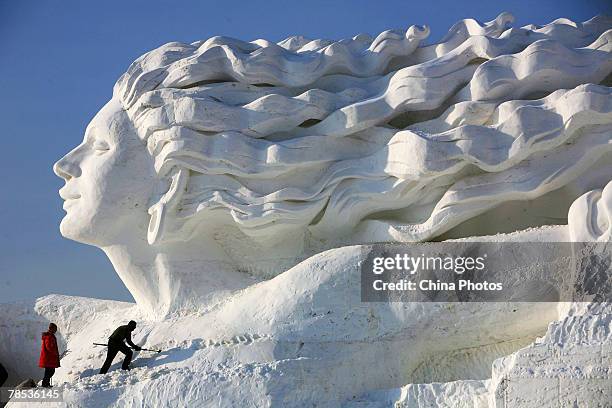 Workers work to make snow sculpture "Romantic Feelings", which will debut at the 20th International Snow Sculpture Art Expo on December 17, 2007 in...