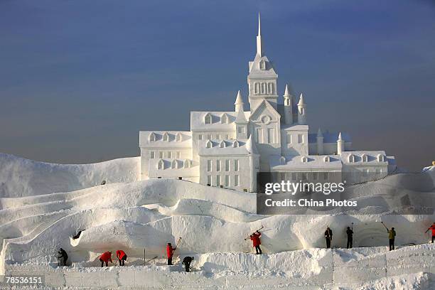 Workers work to make snow sculpture "Romantic Feelings", which will debut at the 20th International Snow Sculpture Art Expo on December 17, 2007 in...