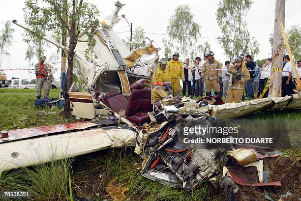 Firefighters work on the debris of a jet that crashed after running out of fuel in Limpio, Paraguay, 20 km from Asuncion, 18 December, 2007. The...