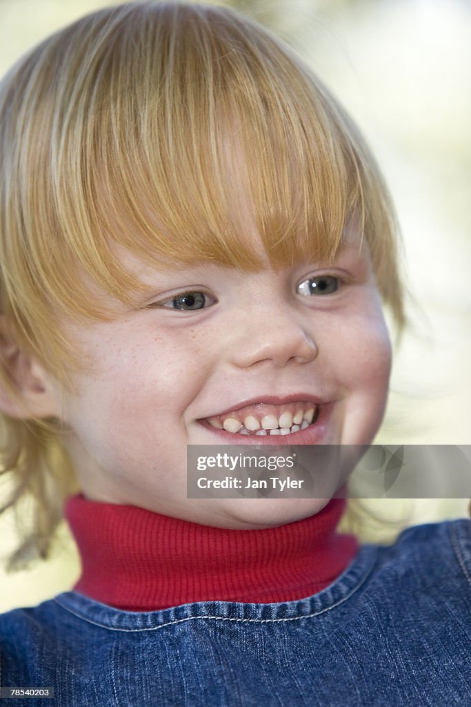 A smiling red-haired child of four.