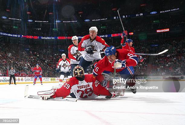 Jay Bouwmeester of the Florida Panthers checks Tom Kostopoulos of the Montreal Canadiens into Tomas Vokoun of the Florida Panthers at the Bell Centre...
