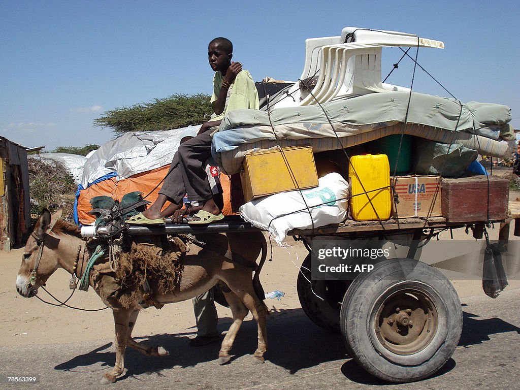 a-somali-man-rides-a-donkey-cart-with-so.jpg