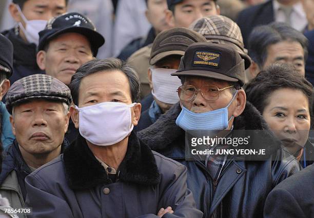 People listen to Chung Dong-Young, South Korean presidential candidate for the pro-government United New Democratic Party, speak during a campaign...