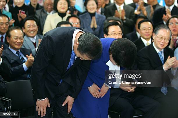 Lee Myung-Bak of the conservative main opposition Grand National Party and his wife Kim Yoon-Ok bow to the applauding audience after he is declared...