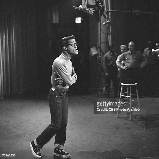 American singer and musician Sammy Davis Jr. , dressed in jeans, high-top tennis shoes, and eyeglasses, speaks to the camera during the filming of an...