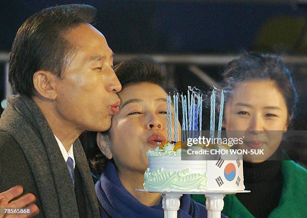 Grand National Party presidential candidate Lee Myung-Bak is helped by his wife Kim Yun-Ok to blow out the candles of his birthday cake presented to...