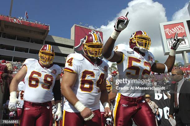 Linebacker Rocky McIntosh and defensive tackle Kedric Golston of the Washington Redskins run to the field before play against the Tampa Bay...