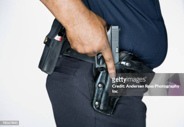 african american male police officer with hand on gun - holster stock pictures, royalty-free photos & images
