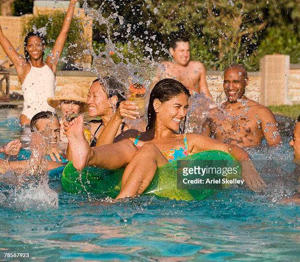 multi-ethnic friends in swimming pool - asian water splash stock-fotos und bilder