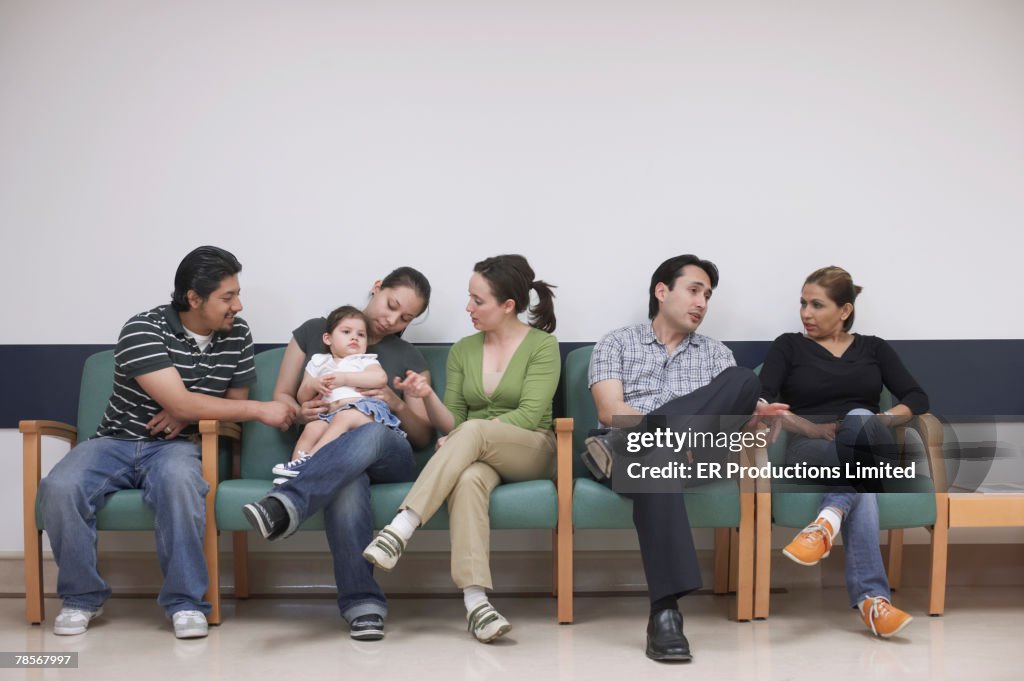 Hispanic family sitting in waiting room