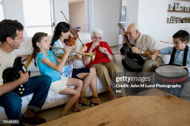 multi-generational hispanic family playing musical instruments - violin family stock pictures, royalty-free photos & images