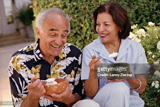senior hispanic couple eating ice cream - mulher colher sorvete imagens e fotografias de stock