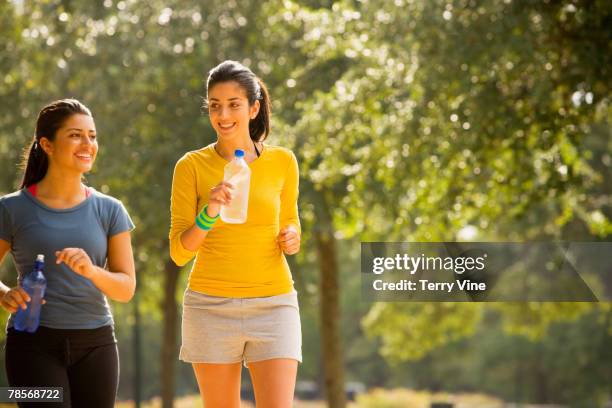 hispanic women walking in park - indian sports and fitness stock pictures, royalty-free photos & images