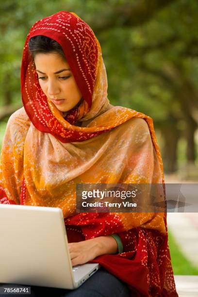 middle eastern woman typing on laptop - dupatta stock pictures, royalty-free photos & images