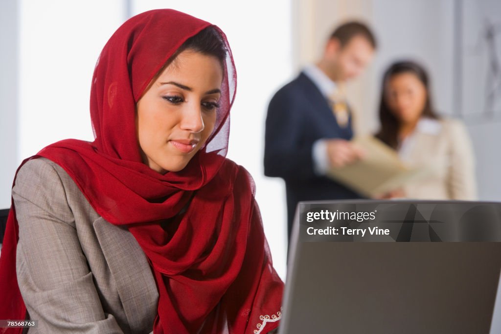 Middle Eastern businesswoman looking at laptop