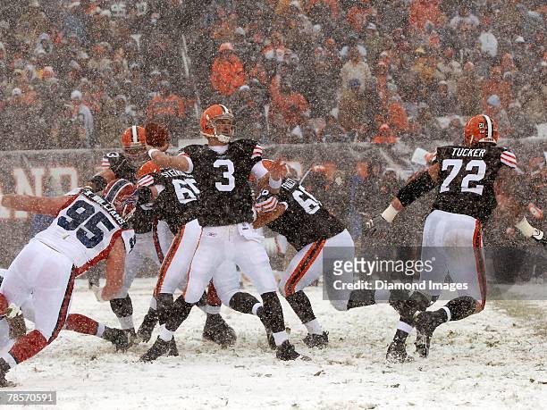 Quarterback Derek Anderson of the Cleveland Browns passes under pressure from defensive lineman Kyle Williams of the Buffalo Bills as as offensive...