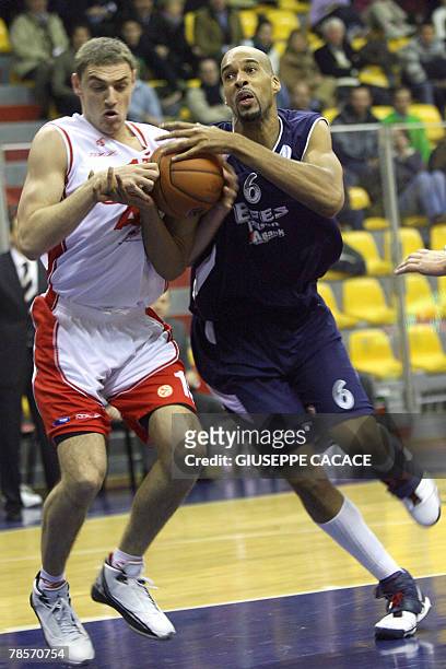 Milan's Lituanian player Mindaugas Katelynas vies for the ball with Istanbul's American player Loren Woods during their Euroleague group B basketball...