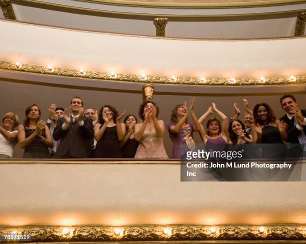 hispanic people applauding in balcony - ovación de pie fotografías e imágenes de stock
