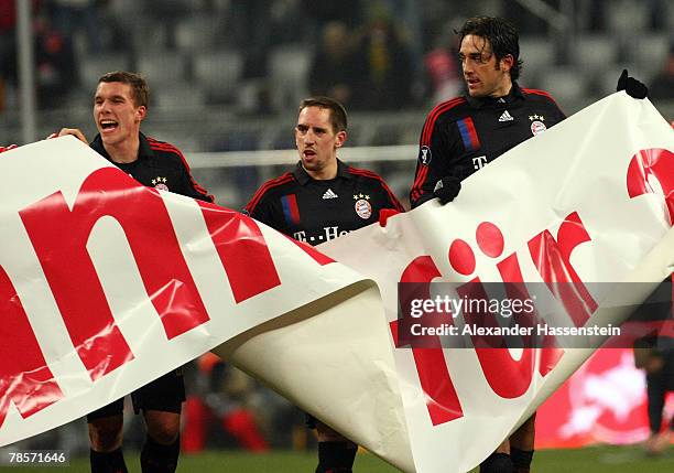 Lukas Podolski, Franck Ribery and Luca Toni of Munich showing their sympathy for the Munich supporters after the UEFA Cup Group F match between...