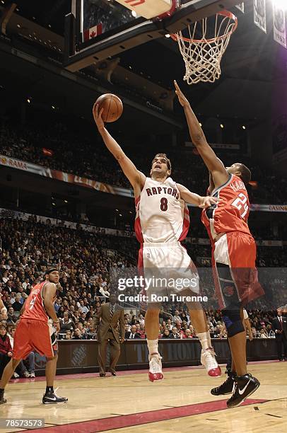 Jose Calderon of the Toronto Raptors lays up a shot against Othella Harrington of the Charlotte Bobcats during the game on December 3, 2007 at the...