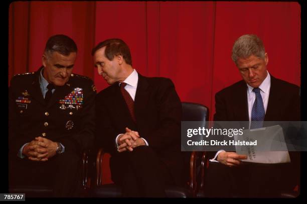 President Bill Clinton reviews notes while General Henry Shelton and Secretary of Defense William Cohen sit February 17, 1998 in Washington, DC....