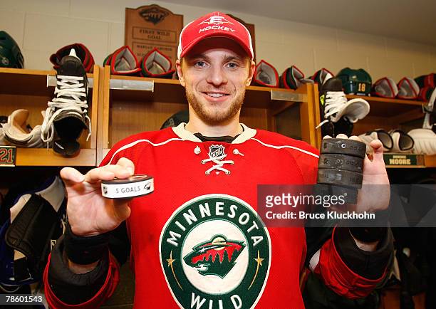 Marian Gaborik of the Minnesota Wild holds the puck from his fifth goal as well as four other pucks representing his other goals scored in the game...