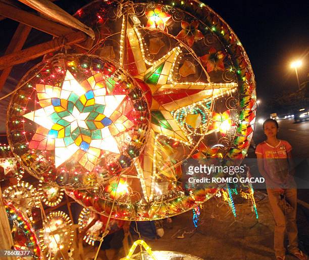 Customer looks at colorful lanterns for sale along a Manila sidewalk, 20 December 2007, as Filipino families decorate their house with bright star...