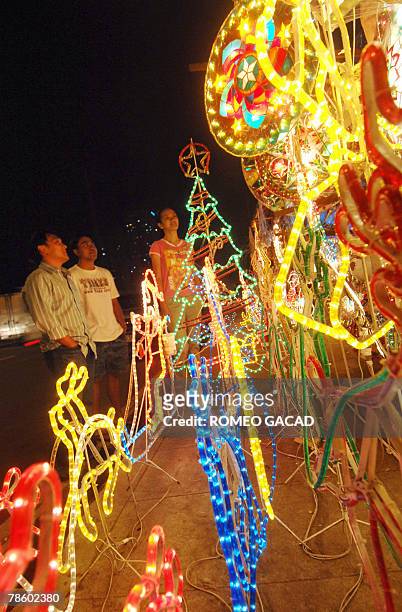 Customers looks at colorful lanterns for sale along a Manila sidewalk, 20 December 2007, as Filipino families decorate their houses with bright star...