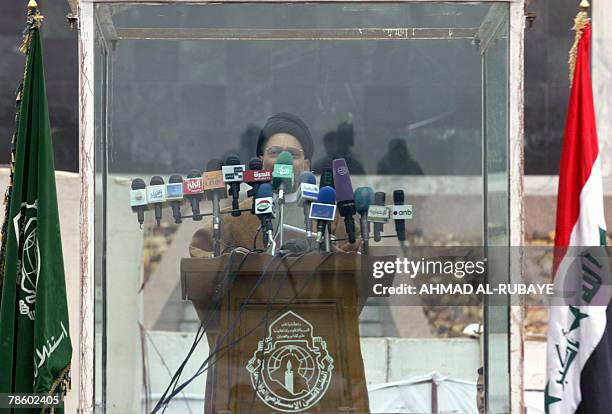 Sheikh Abdel Aziz al-Hakim, head of the Supreme Iraqi Islamic Council , addresses, behind a bullet-resistant barrier, Iraqi Shiites celebrating Eid...