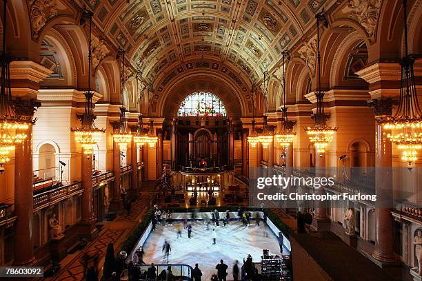 Skaters get into the festive spirit as they skate around the synthetic ice rink that has been installed inside the historic St George's Hall in on...