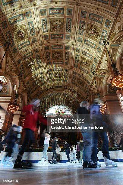 Skaters get into the festive spirit as they skate around the synthetic ice rink that has been installed inside the historic St George's Hall on...